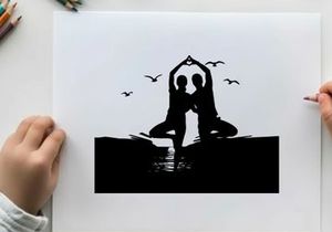 Silhouette of two people doing yoga on the beach at sunset
