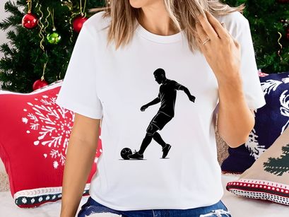Silhouette of a soccer player kicking a ball in action
