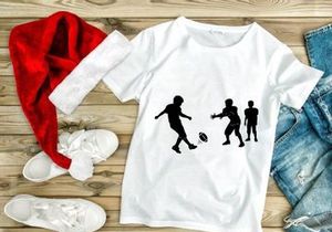 Silhouette of three boys playing rugby with a ball on a field