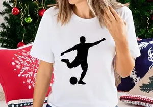 Silhouette of a soccer player kicking a ball in mid action