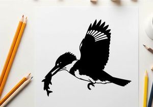 Silhouette of a kingfisher in flight with fish