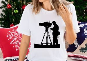 Silhouette of a cameraman operating a large video camera on a tripod stand