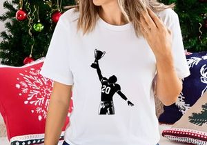 Victorious football player holding trophy in air with number 20 jersey