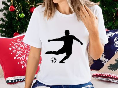 Soccer player kicking a ball in motion silhouette