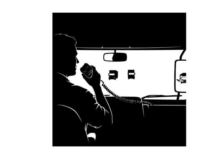 Silhouette of a man driving and talking on a phone