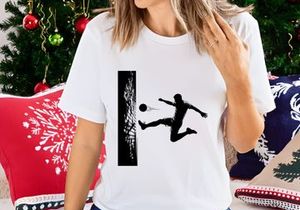 Soccer player kicking ball in mid air near goal net in black and white