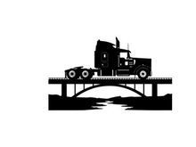 Silhouette of a semi truck on a bridge over a river