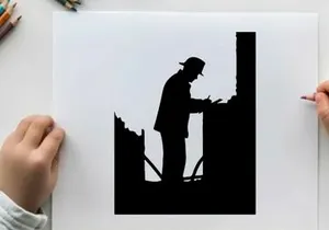 Silhouette of a man working on a construction site at night