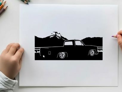 Silhouette of a pickup truck in front of mountains