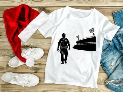 Police officer walking towards stadium with bright floodlights at night