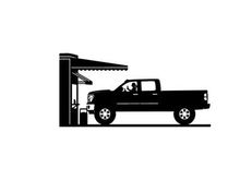 Silhouette of a pickup truck refueling at a gas station