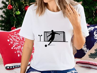 Soccer player kicking ball into goal with silhouette