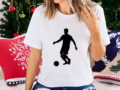 Silhouette of a soccer player kicking a ball in action