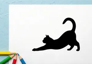 Silhouette of a playful black cat stretching on a white background