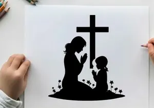 Silhouette of mother and child praying by cross