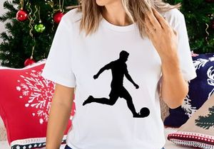 Silhouette of a soccer player kicking a ball in motion