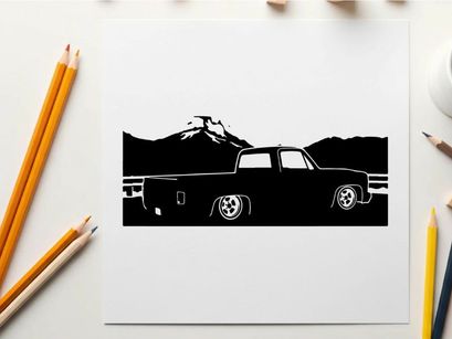 Silhouette of a pickup truck in front of mountains