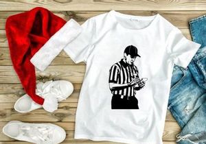 A referee in a black and white striped shirt checking a mobile phone