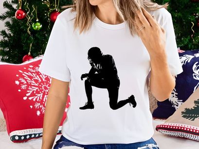 American football player in a kneeling position on the field in black silhouette