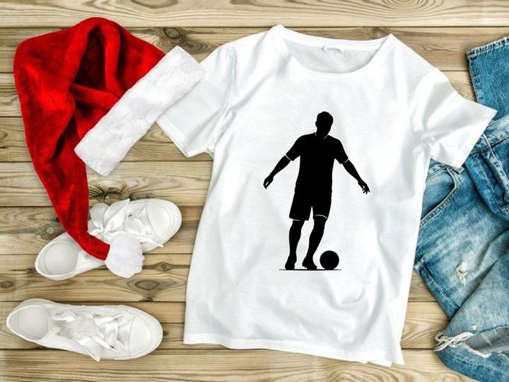 Silhouette of a soccer player kicking a ball in action
