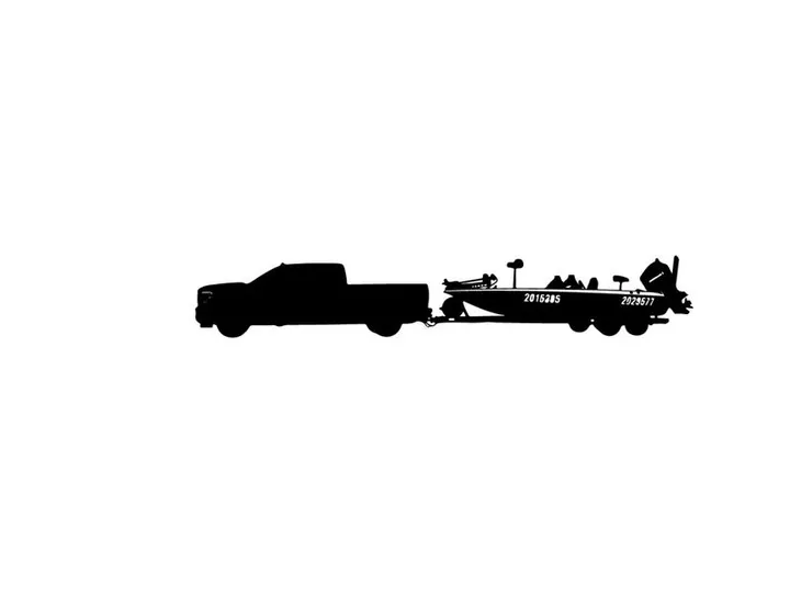 Silhouette of a pickup truck towing a fishing boat