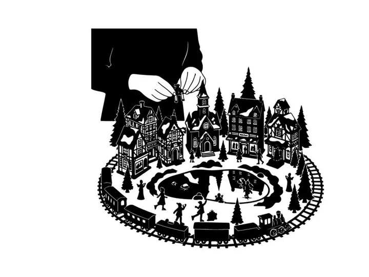 Silhouette of a person building a miniature winter village scene