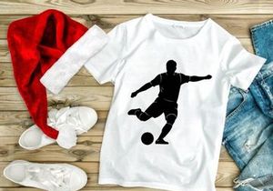 Silhouette of a soccer player kicking a ball in mid action