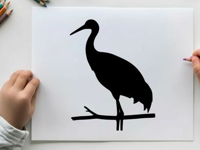 Silhouette of a heron perched on a branch in profile view