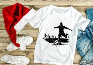 Soccer player kicking ball in rain with teammates in background on field