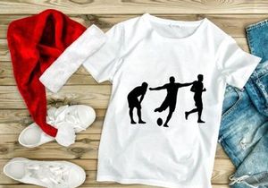 Silhouette of three soccer players in action kicking ball