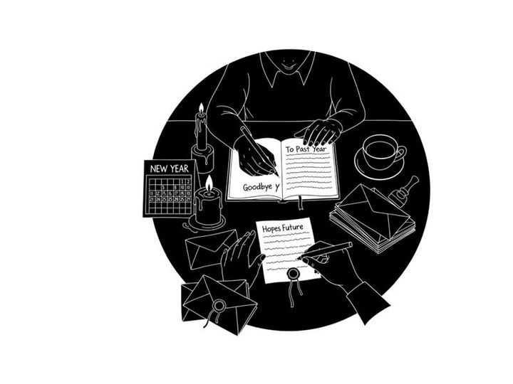 Silhouette of a person reading a book at a desk with stationery