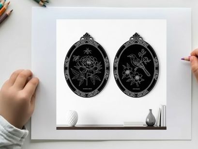 Silhouette artwork of two ornate oval frames on a shelf