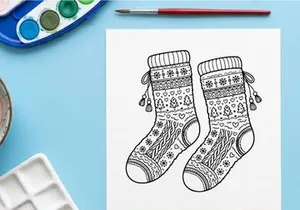 Pair of festive Christmas knit socks with snowflake and reindeer patterns hanging on ribbon