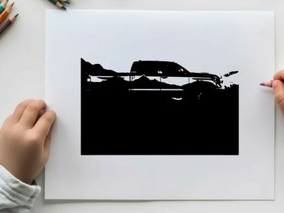 Silhouette of a pickup truck against a mountain range silhouette