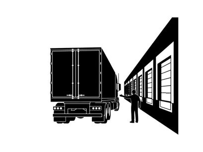 Silhouette of a man directing a semi truck to a warehouse dock