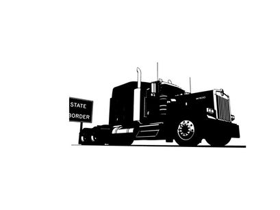 Silhouette of a large truck on the road with a sign
