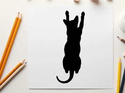 Silhouette of a cat jumping up with front paws raised high