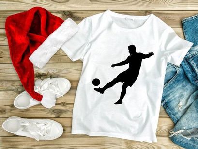Silhouette of a soccer player kicking a ball in mid action