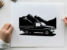 Silhouette of a pickup truck in front of mountains