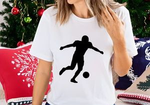 Silhouette of a soccer player kicking a ball in mid action