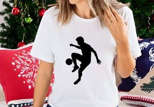 Silhouette of a soccer player kicking a ball in mid action
