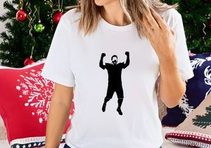 A man in black clothing jumping up with arms raised in celebration or triumph