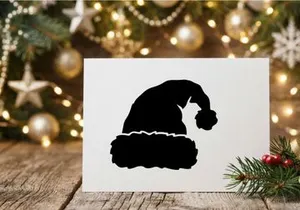 Silhoueta de un gato sentado en una rama de árbol de Navidad por la noche
