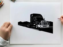 Silhouette of a semi truck on a highway with mountains