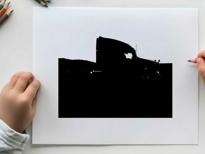 Silhouette of a semi truck driving on a road with mountains