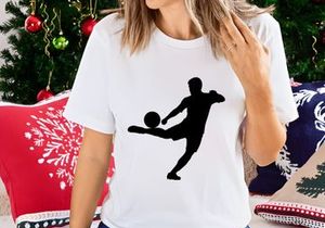 Silhouette of a soccer player kicking a ball in mid action