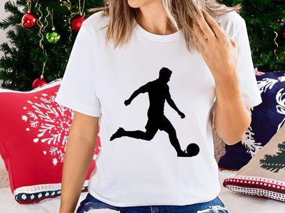 Silhouette of a soccer player kicking a ball in motion