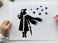 Silhouette of a person in winter clothes holding umbrella