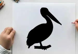 Silhouette of a pelican standing on a branch