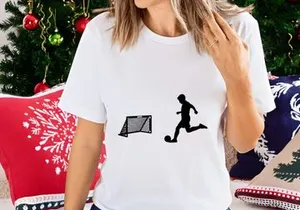 Silhouette of soccer player kicking ball towards goal